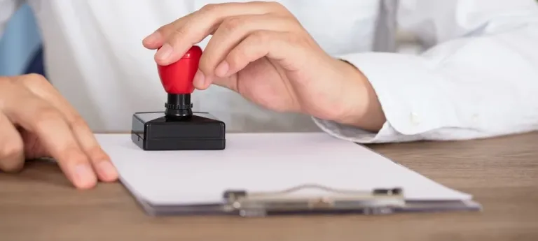 Une personne appose un tampon sur un document