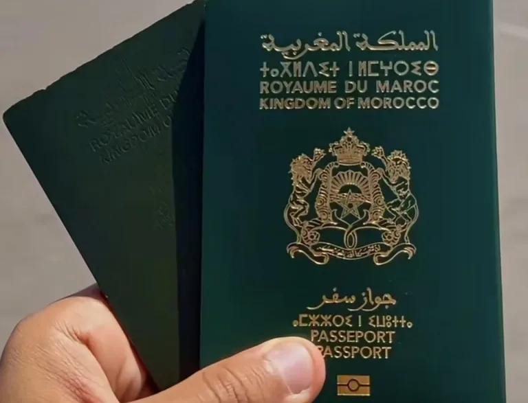 Une main tient deux passeports marocains